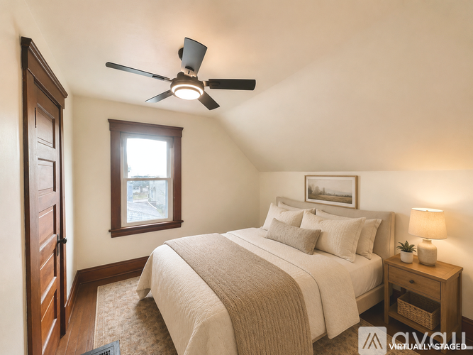 A bedroom with a bed, a ceiling fan, and a window.