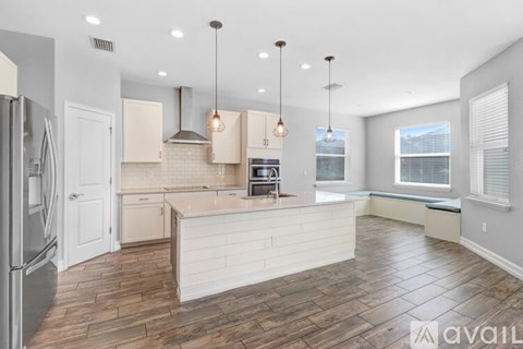 A kitchen with a refrigerator on the left and a countertop with a sink.