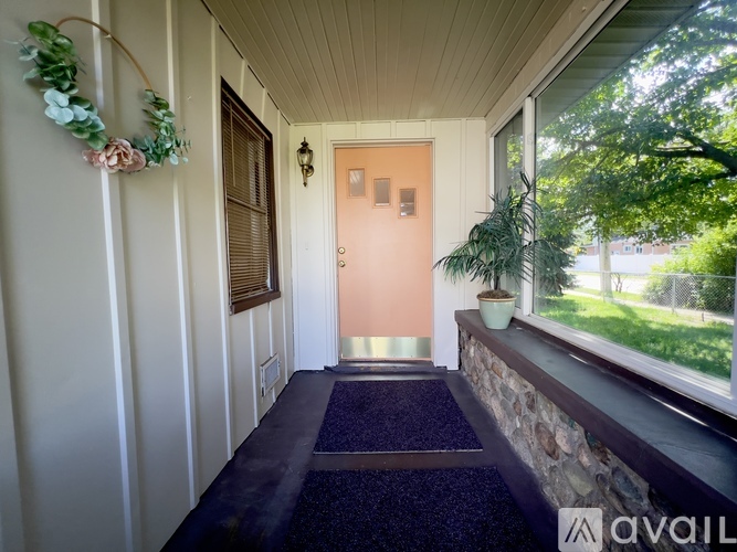 A garage with a white door is situated in front of a house.