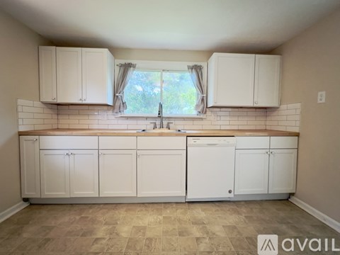 A kitchen with white cabinets and a tiled backsplash.