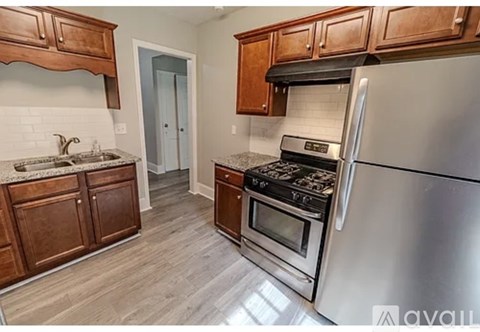A kitchen with wooden cabinets and a stainless steel refrigerator.