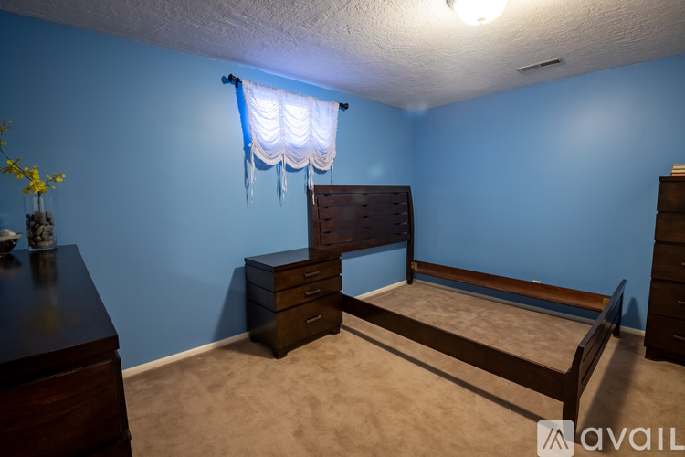 A bedroom with a bed, dresser, and nightstand.