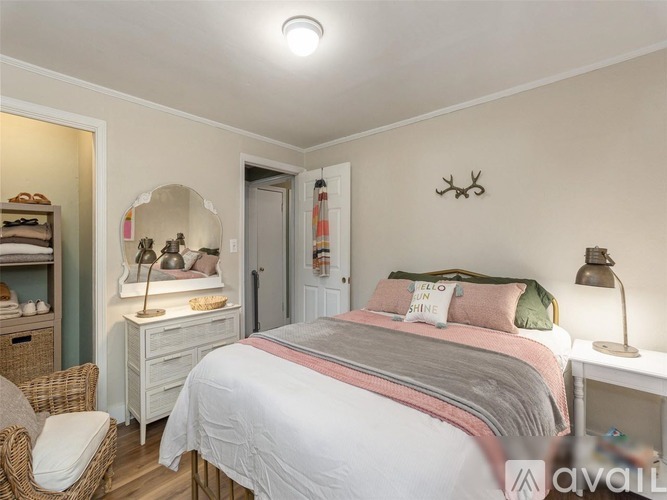 A bedroom with a bed, nightstand, and chair.