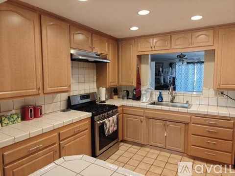 A kitchen with wooden cabinets and a black stove top oven.