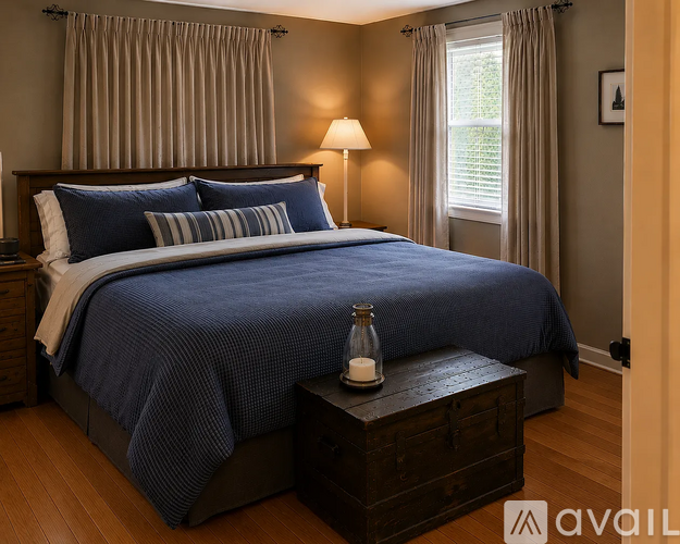 A bedroom with a large bed and a wooden nightstand.
