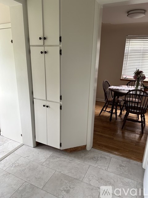 A kitchen with a table and chairs in the background.