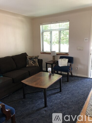 A living room with a couch, chair, and table.