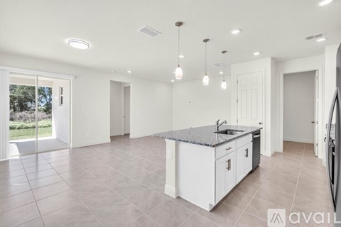 A kitchen with white cabinets and a granite countertop.