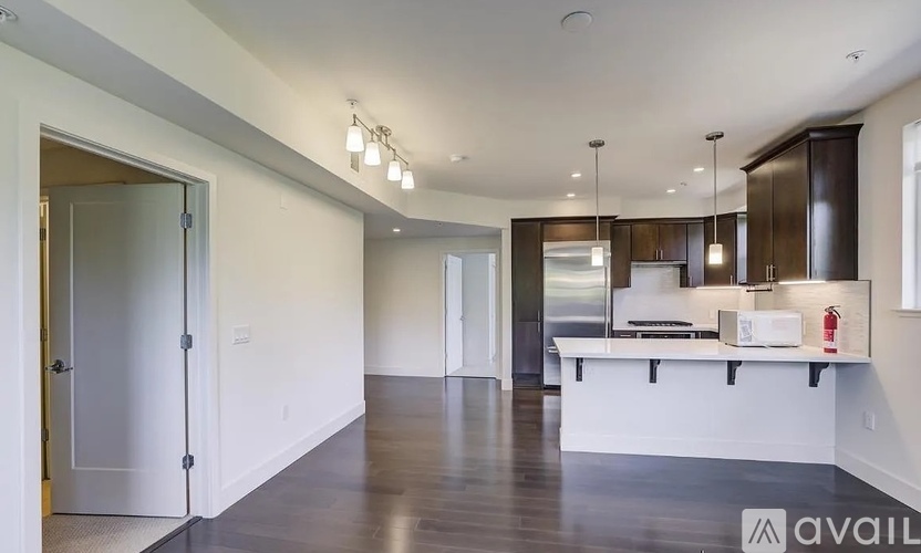 A spacious kitchen with dark wood cabinets and a white island.