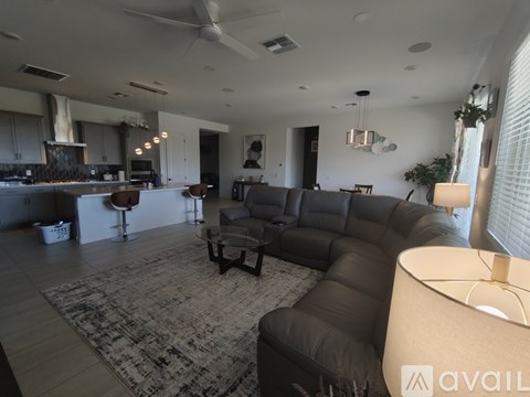 A modern living room with a black leather sofa and a rug.