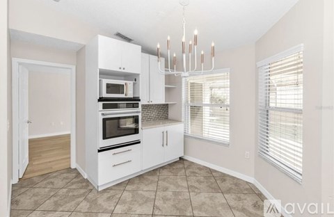 A kitchen with white cabinets and a chandelier.
