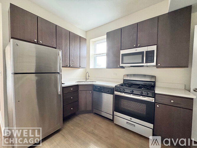 A kitchen with a stainless steel refrigerator, oven, and microwave.