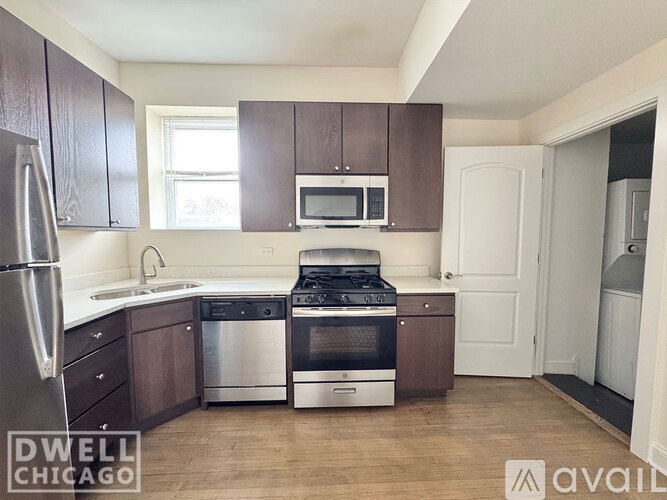 A kitchen with dark wood cabinets and stainless steel appliances.