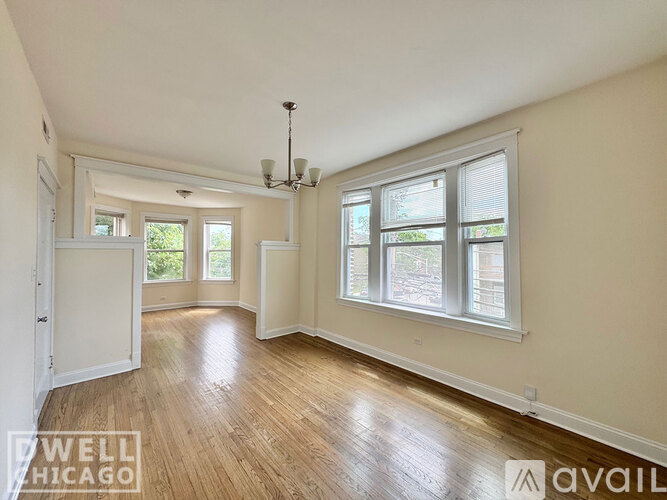 A well-lit room with wooden floors and a chandelier.