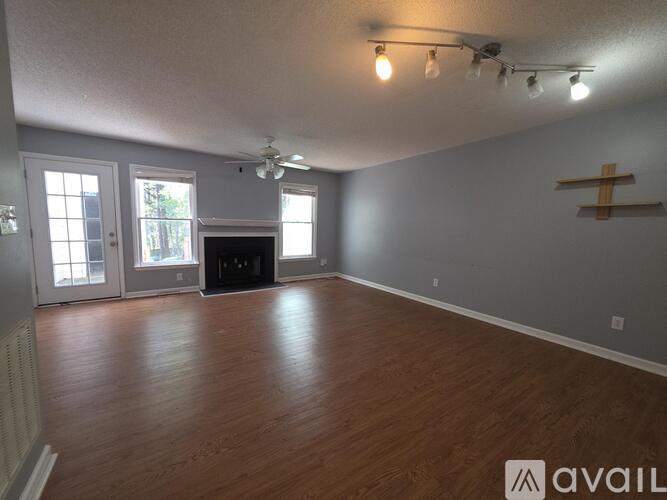 A living room with a fireplace and a ceiling fan.