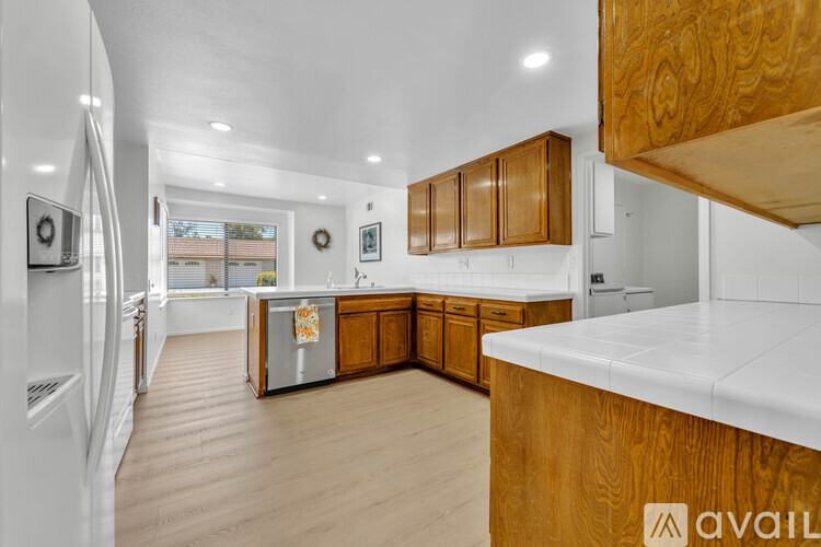 A modern kitchen with wooden cabinets and a white countertop.