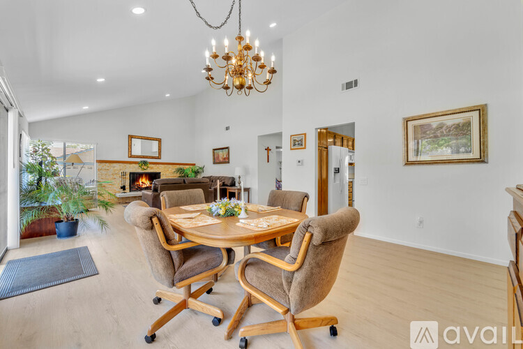 A dining room with a wooden table and chairs.