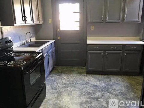 A kitchen with a black stove top oven and a black dishwasher.