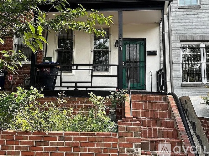 A house with a green door and a mailbox on the steps.