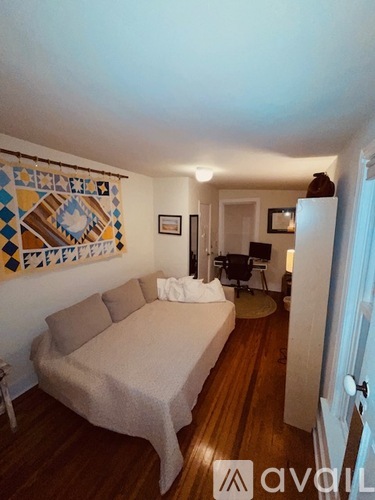 A bedroom with a bed and a chair in it.