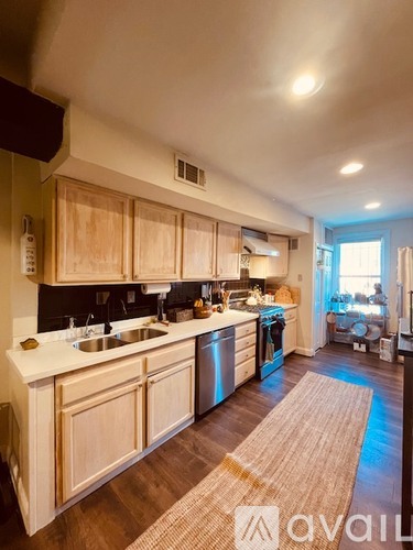 A kitchen with wooden cabinets and a rug on the floor.