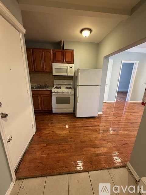 A kitchen with a white refrigerator, white stove, and white oven.