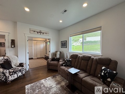 A living room with a brown couch and a chair.