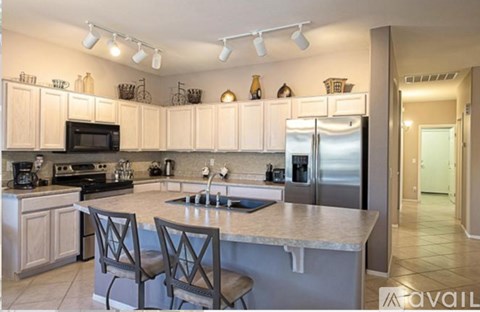 A kitchen with a center island and a refrigerator on the right.