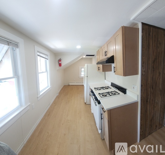 A kitchen with wooden cabinets and a white stove top oven.