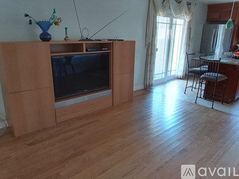 A living room with a television and a dining table.