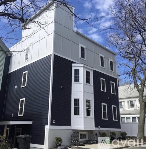 A modern two-story building with a combination of white and dark blue exterior.