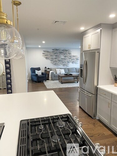 A modern kitchen with a white countertop and a stove top oven.