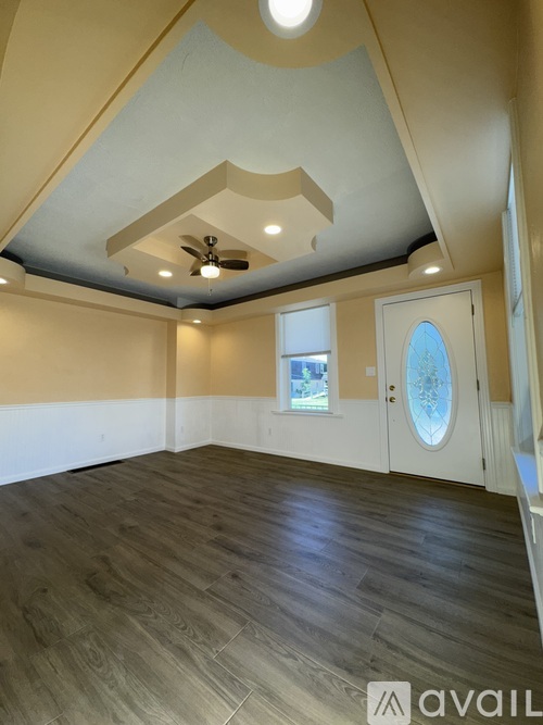 A room with wooden flooring and a ceiling fan.