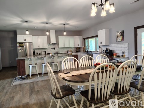 A kitchen with a table and chairs in front of it.