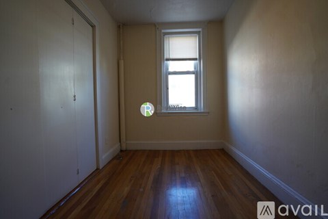 A room with a window and wooden floors.