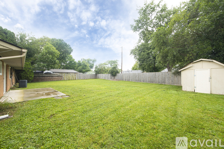 A backyard with a fence and a shed.