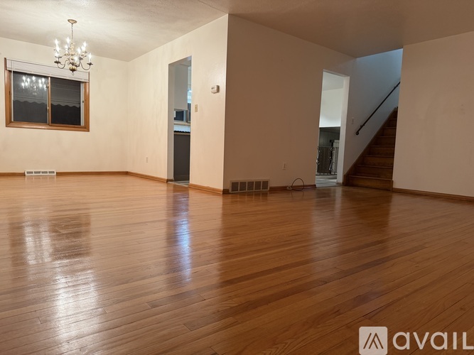 A room with wooden floors and a chandelier.