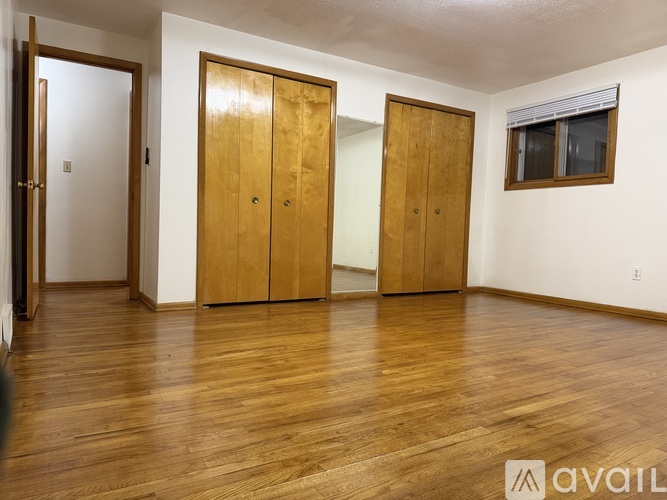 Three wooden doors in a room with hardwood floors.