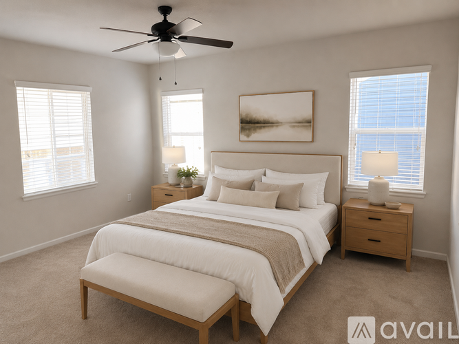 A bedroom with a large bed, a ceiling fan, and two windows.