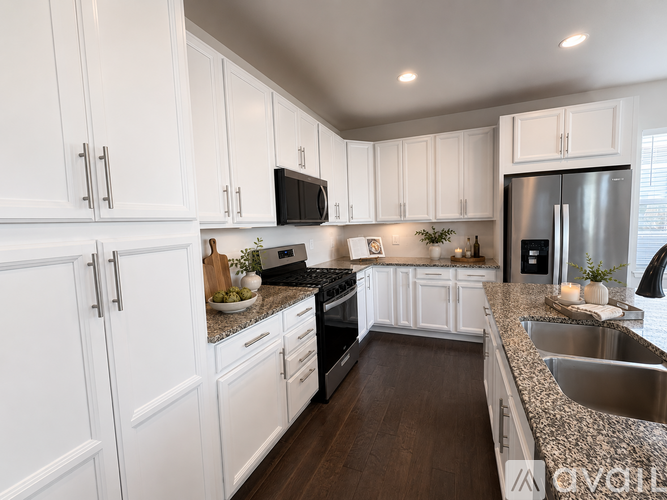 A kitchen with white cabinets and a granite countertop.