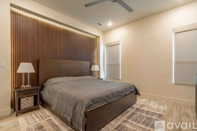 A bedroom with a large bed and a wooden headboard.