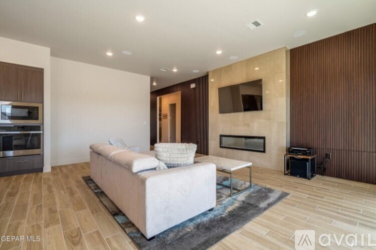 A modern living room with a white sofa and wooden flooring.