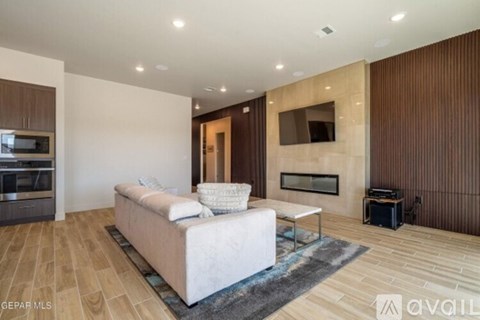 A modern living room with a white sofa and wooden flooring.