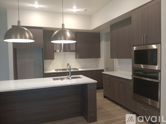 A modern kitchen with dark wood cabinets and stainless steel appliances.