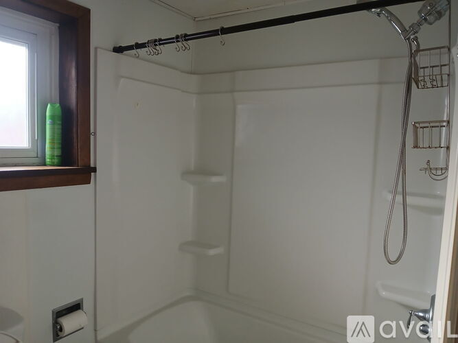 A white bathroom with a shower and a window.