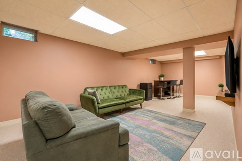 A living room with a green couch and a flat screen TV.