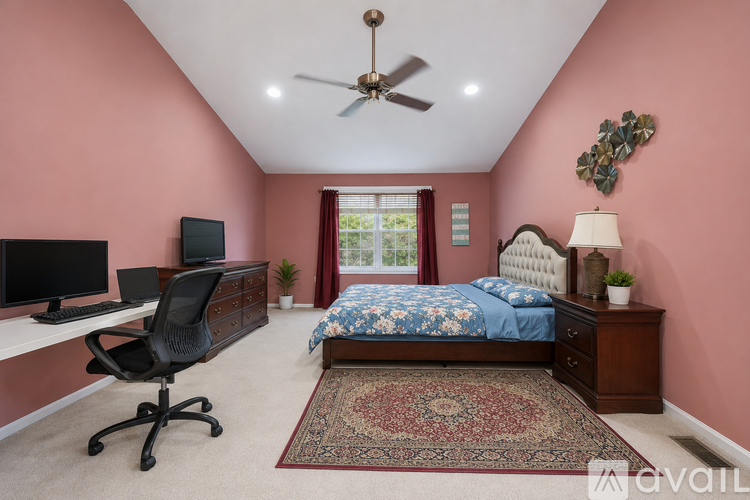A bedroom with a bed, desk, and chair.