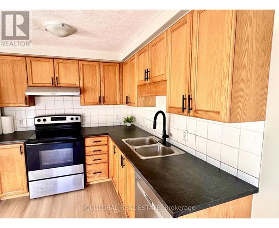 A kitchen with wooden cabinets and a black stove top oven.