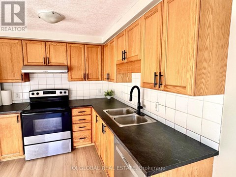 A kitchen with wooden cabinets and a black stove top oven.