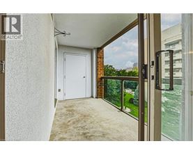 A balcony with a white door and a glass door leading to a view of a river.